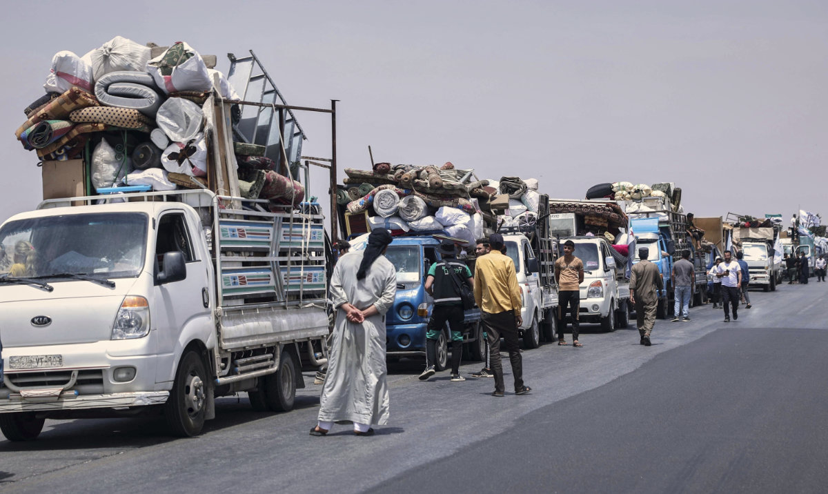 Trucks carrying around 60 displaced families gather on the highway as they head to their village, Kafr Sijna, after more than five years in the Atmeh camps near the Syrian-Turkish border, on a highway north of Kafr Sijna, Syria, Sunday, May 18, 2025. (AP)