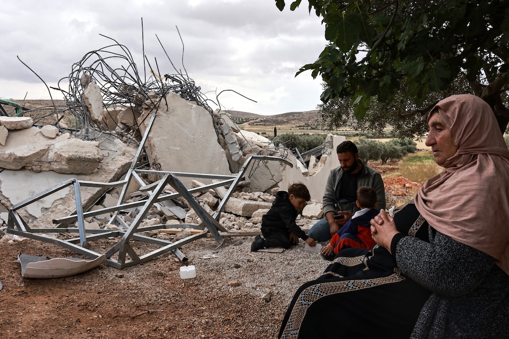 A Palestinian woman reacts as she sits next to the rubble her house after it was demolished by Israeli forces in the village of Mughayyir Al-Deir, north of Ramallah in the occupied West Bank, on May 5, 2025. (AFP)