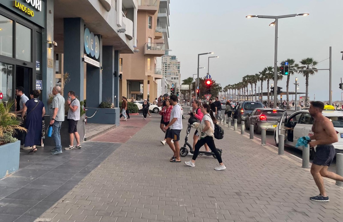 People run for cover during a missile alert in Tel Aviv on May 13, 2025. (AFP)