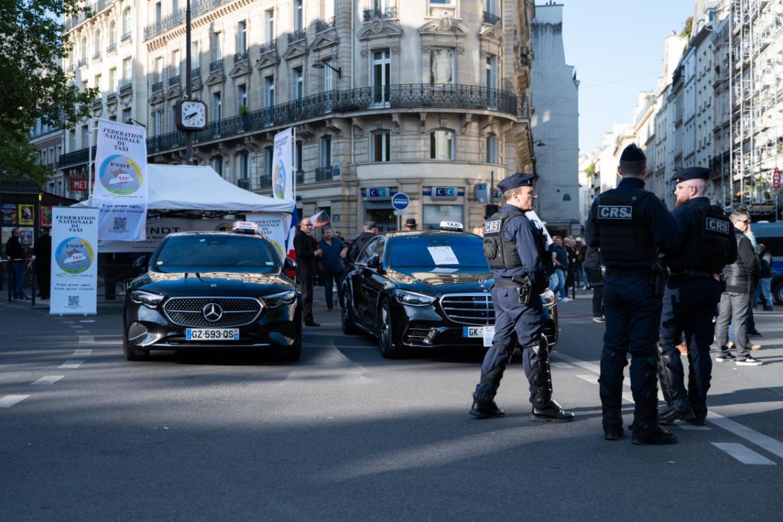 Taxis gather in a street, next to French Republican Security Corps (CRS - Compagnies Republicaines de Securite) police officers, in Paris early on May 19, 2025. (AFP)
