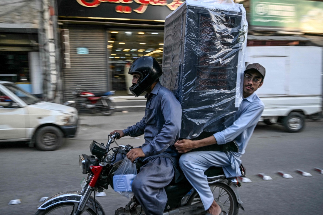 Men transporting an air cooler in Rawalpindi, Pakistan. (AFP)