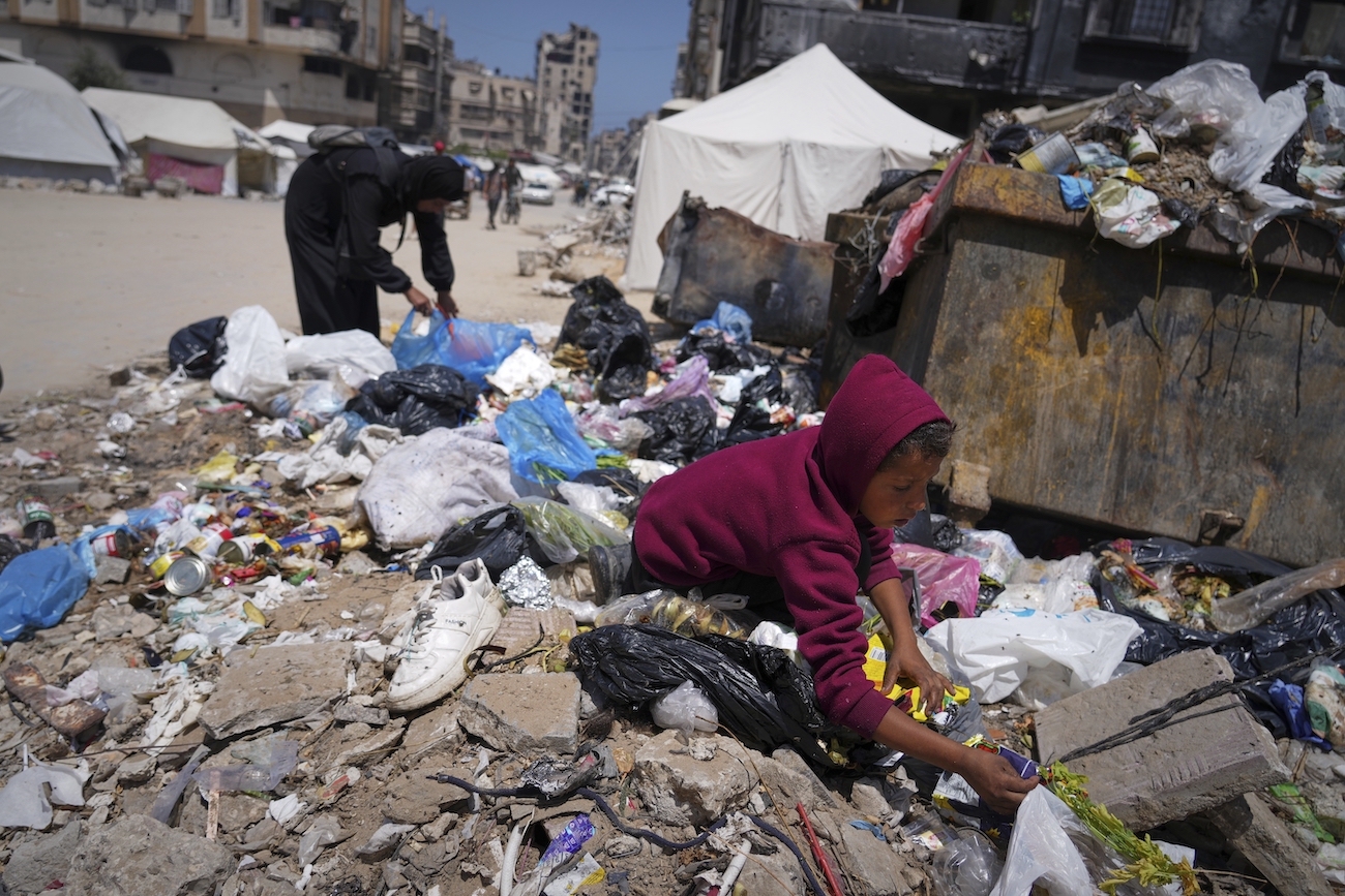A boy looks for some food on a pile of garbage in Gaza City, Sunday, May 25, 2025. (AP)
