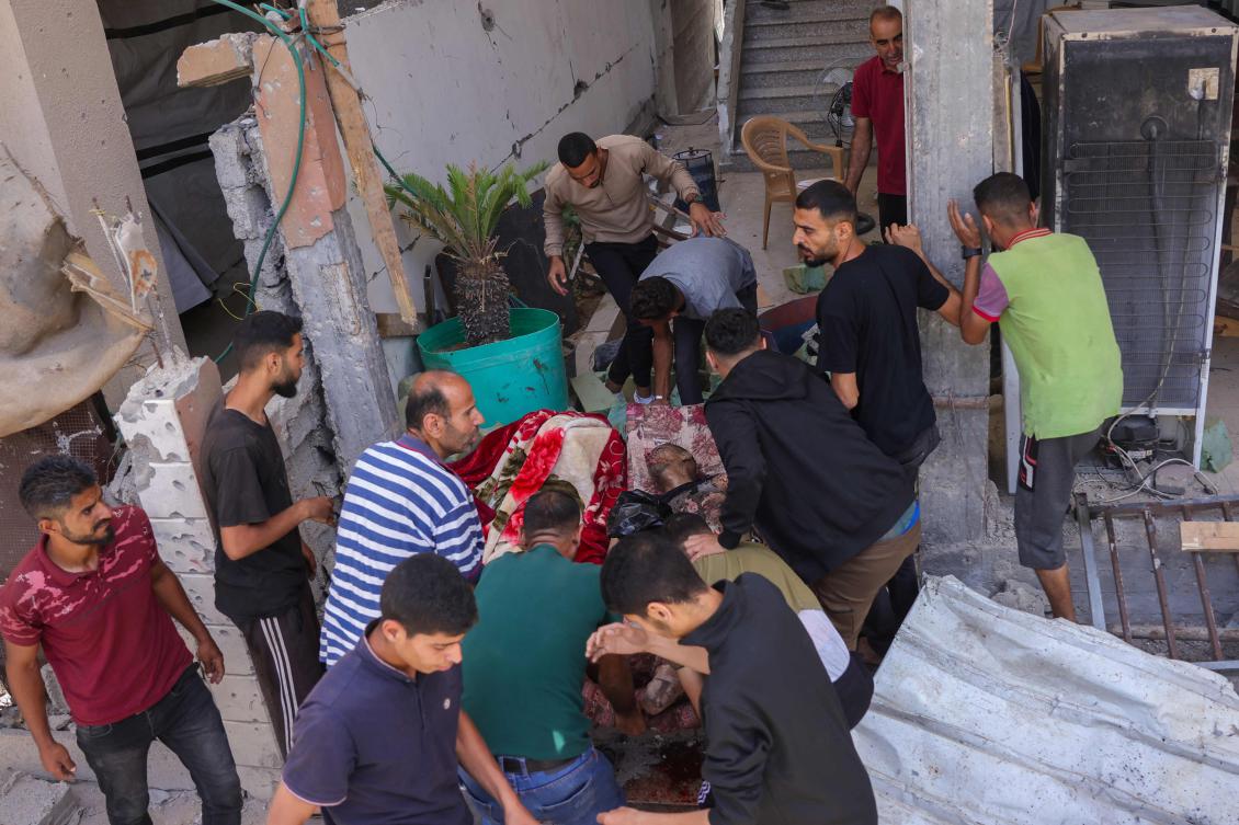 Above, Palestinians carry the body of a man killed in an Israeli strike in the Saftawi neighborhood west of Jabalia in the northern Gaza Strip on May 27, 2025. (AFP)