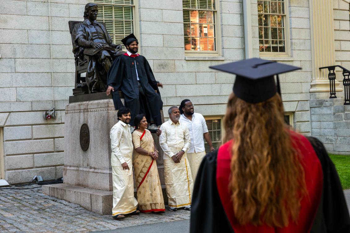 Graduating students, faculty and family gather in front of the statue of John Harvard in Harvard Yard on May 28, 2025 in Boston, Massachusetts. (Getty Images via AFP)