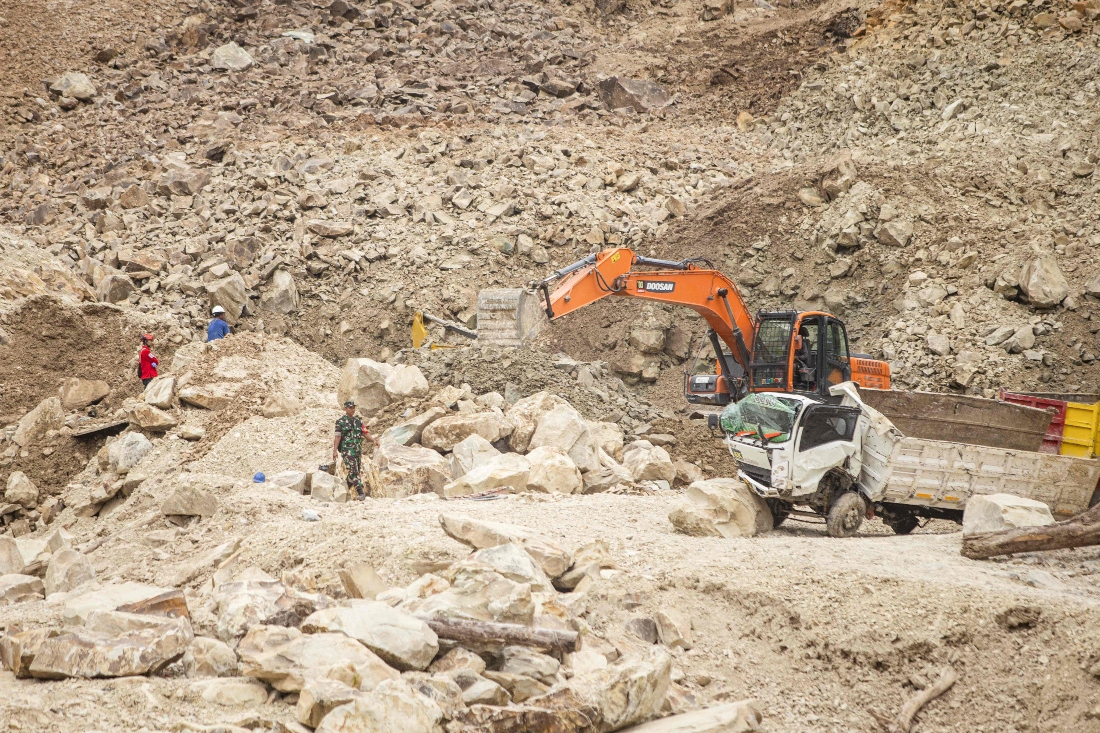 Rescuers use heavy equipment to search for landslide victims buried under rocks at the C excavation site in Cipanas, Dukupuntang, Indonesia. (AFP)