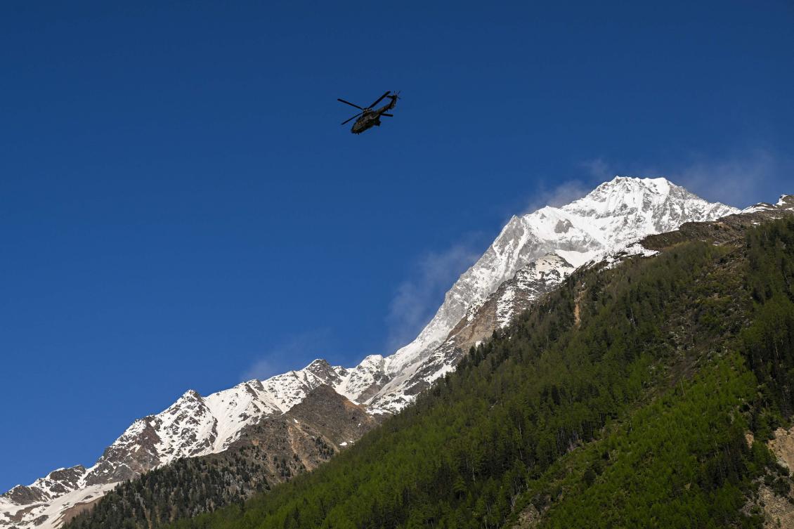 A Super Puma of Swiss air forces flies next to the Bietschhorn mountain above Wiler, on May 30, 2025, after the huge Birch Glacier collapsed and a massive landslide destroyed the evacuated small village of Blatten in the Swiss Alps. (AFP)