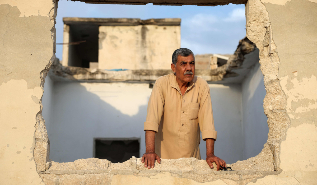 A Syrian looks out of a window in his destroyed house in Hama province. (AFP)