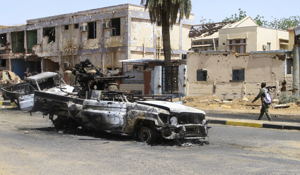A Sudanese man walks past destroyed military vehicles in front of a hospital in Khartoum on April 28, 2025. (AFP)