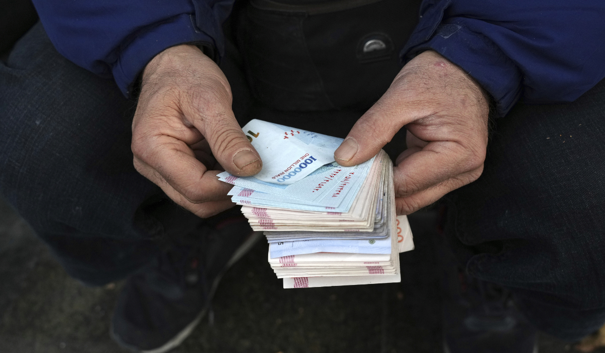 A street money exchanger counts Iranian banknotes in downtown Tehran, Iran. (AP file photo)