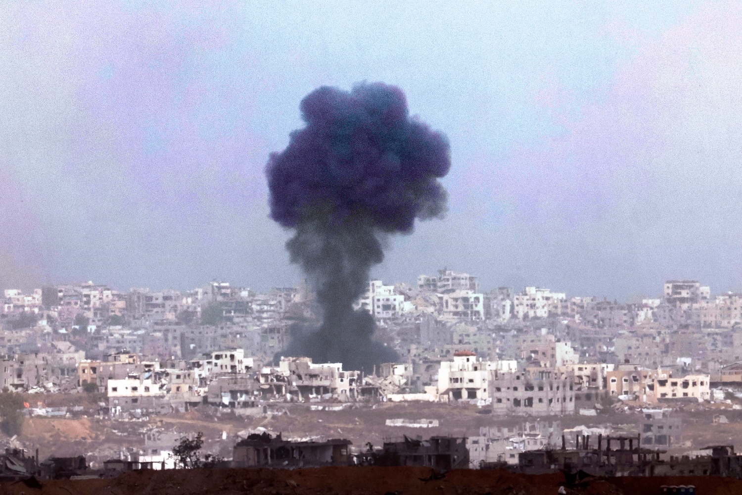 Smoke billows above destroyed buildings during Israeli bombardment in Gaza. May 27, 2025 (File/AFP)