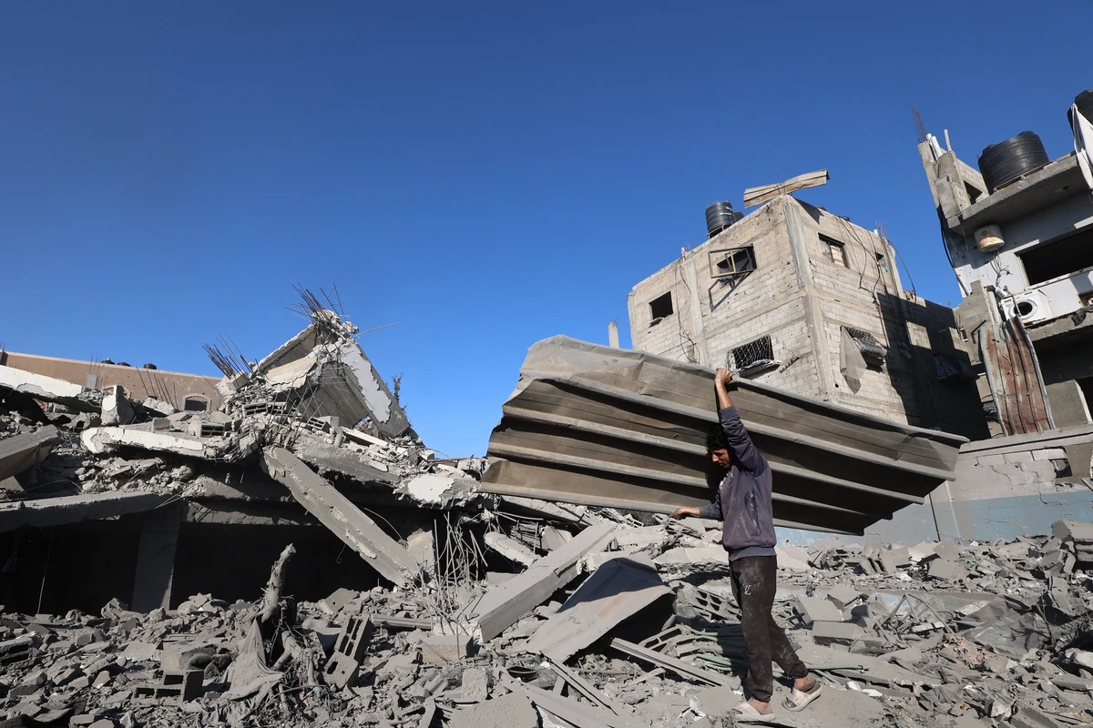 A Palestinian man carries debris as he clears rubble, following overnight Israeli strikes, at the Nuseirat refugee camp in the central Gaza Strip, Apr. 29, 2025. (AFP)