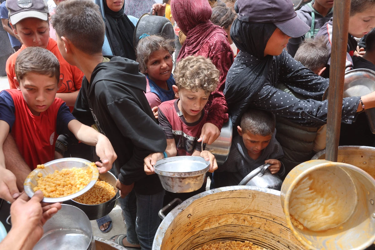 Palestinian children queue for a hot meal at a charity kitchen in Gaza City on April 30. (AFP)