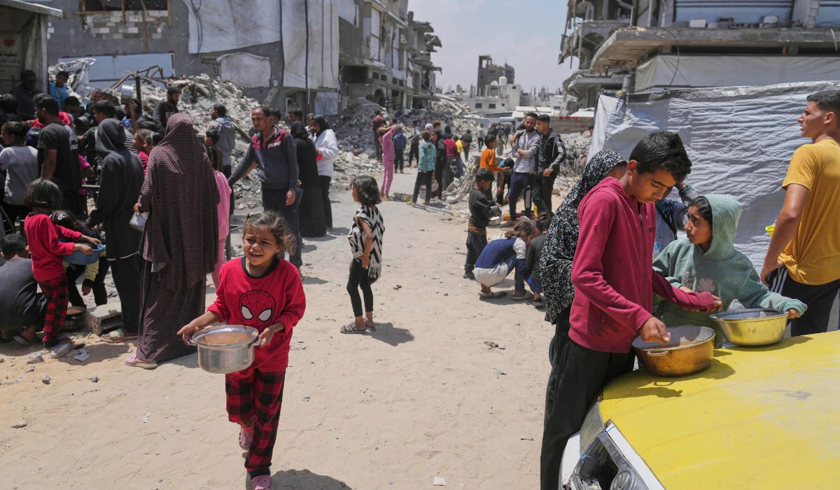 Palestinians receive donated food at a community kitchen in Beit Lahia, northern Gaza Strip, Saturday, May 3, 2025. (AP)