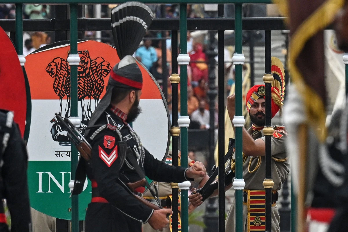 A Pakistani Ranger (L) and an Indian Border Security Force (BSF) soldier perform during the 'Beating Retreat' ceremony at the border gates of Pakistan and India, at the Wagah border post near Lahore on May 4, 2025. (AFP)