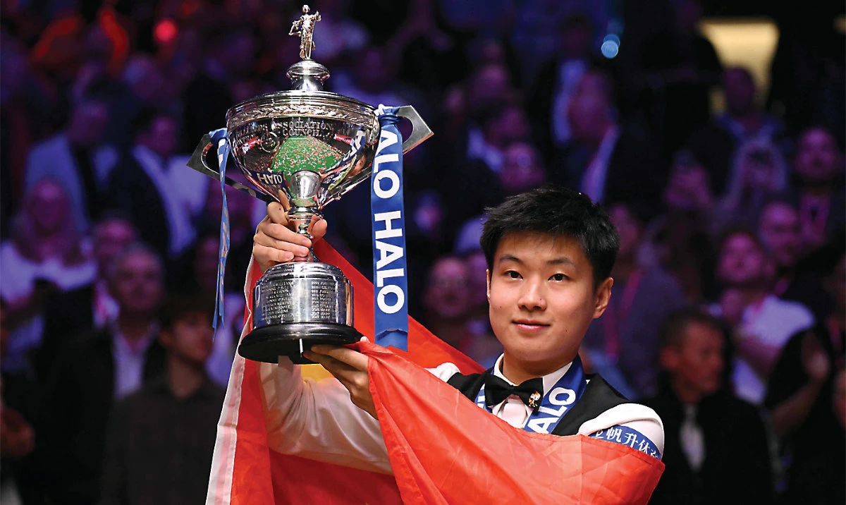 China’s Zhao Xintong with the trophy after victory over Wales’ Mark Williams in the World Championship Snooker final at The Crucible in Sheffield, northern England on Sunday. (AFP)