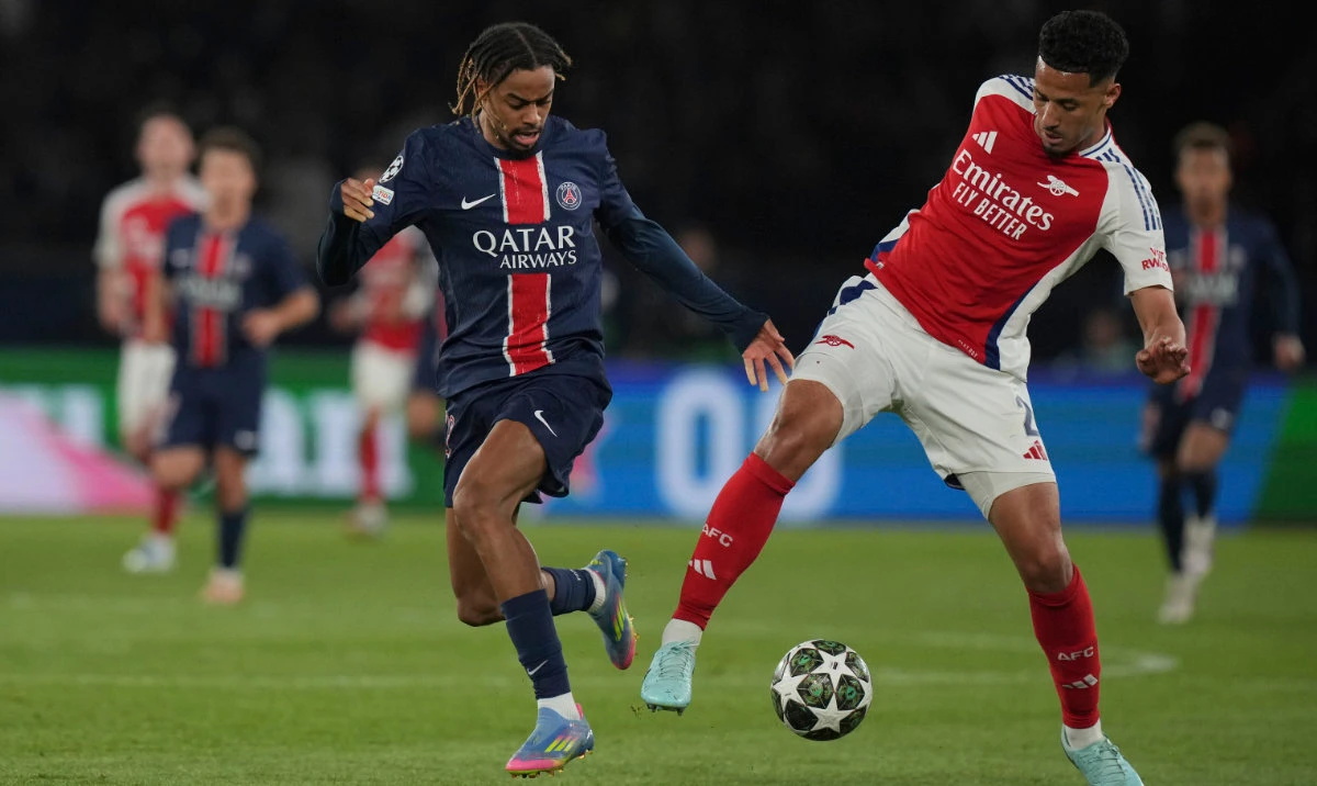 Arsenal's William Saliba, right, challenges PSG's Bradley Barcola during the Champions League semifinal, second leg soccer match between Paris Saint-Germain and Arsenal at the Parc des Princes in Paris, Wednesday, May 7, 2025. (AP)