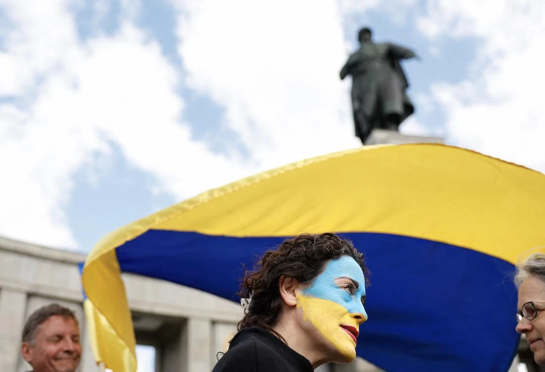 A Ukraine supporter with her face painted in Ukraine's colours stands with a Ukraine flag at the Soviet War Memorial Tiergarten. (File/AFP)
