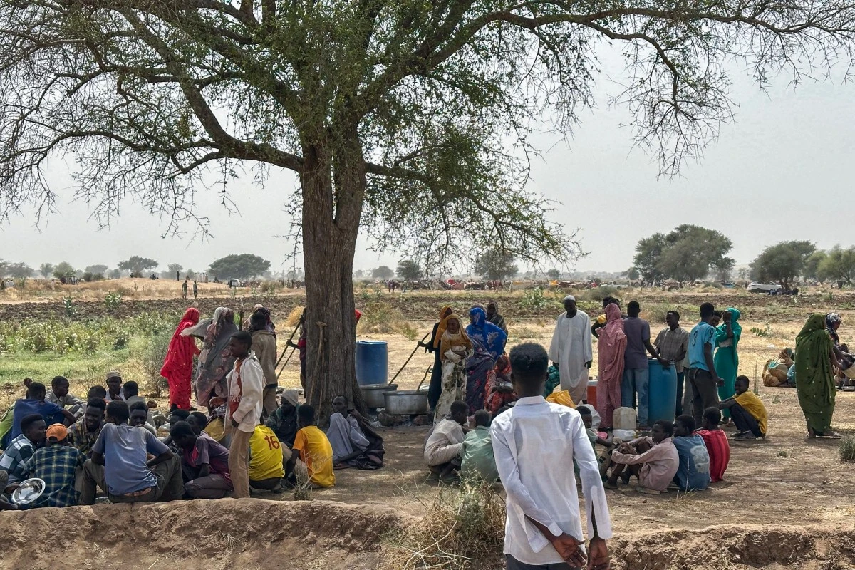 People who fled the Zamzam camp for the internally displaced after it fell under RSF control, gather for communal cooking in a makeshift encampment in an open field near the town of Tawila in war-torn Sudan's western Darfur region on April 13, 2025. (AFP)