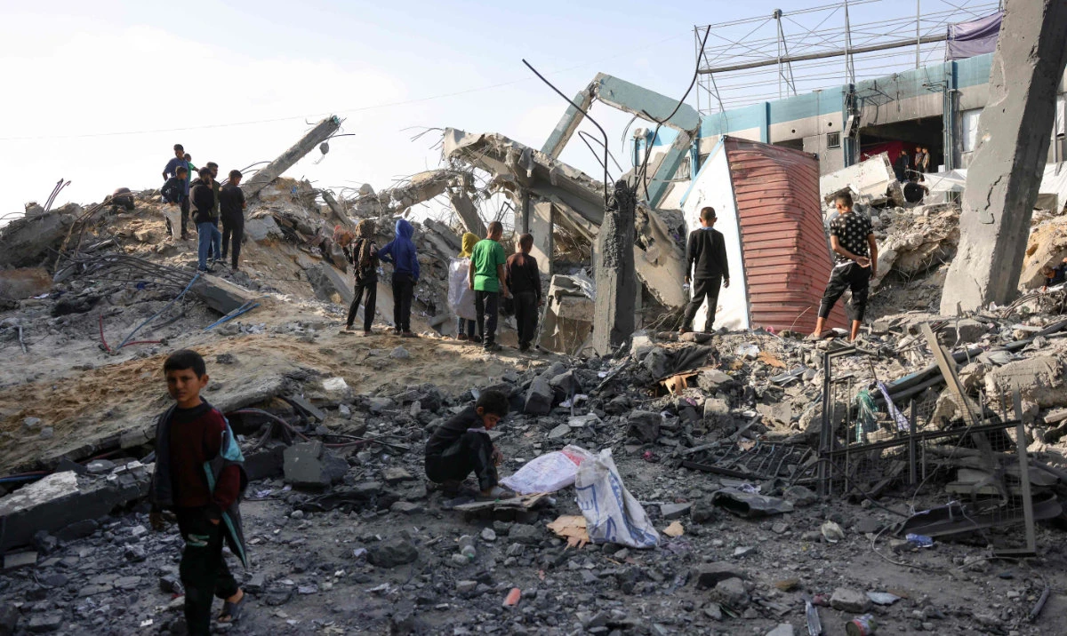 Palestinian children gather amid the rubble of an UNRWA school-turned-shelter, heavily damaged in an overnight Israeli strike in Jabalia in the northern Gaza Strip on May 10, 2025. (AFP)