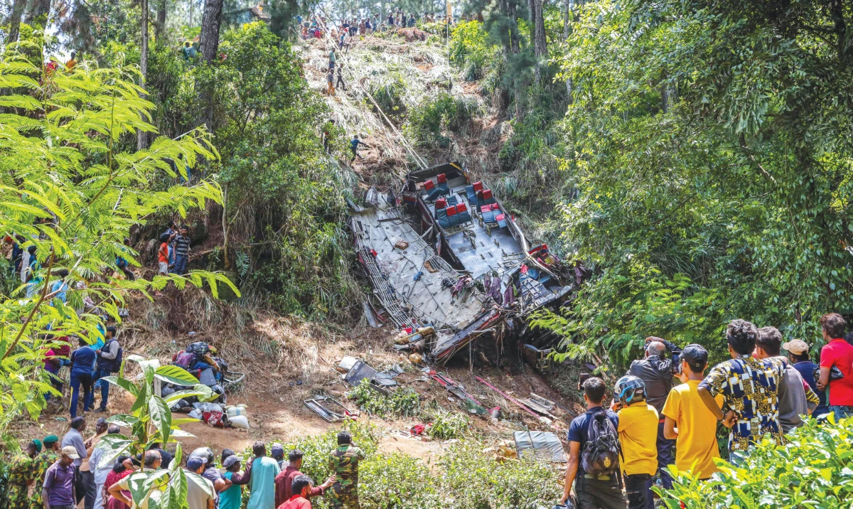 People gather at the site of a bus accident in the central hilly region of Kotmale, Sri Lanka on Sunday. (AFP)