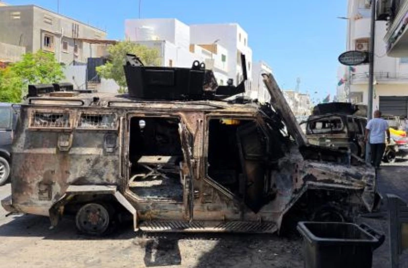 A man walks next to cars destroyed during overnight clashes in the southern district of Abu Salim in the Libyan capital Tripoli on May 13, 2025. (AFP)