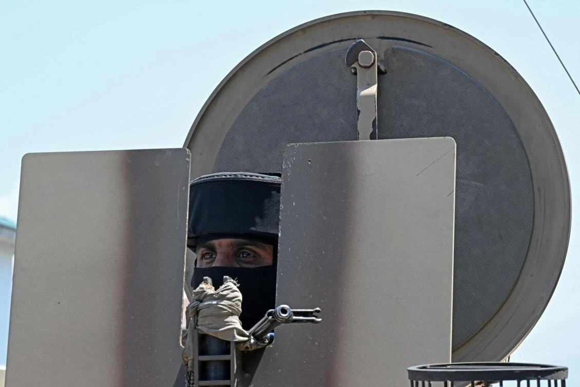 An Indian paramilitary trooper stands guard on an armoured vehicle parked along a street in Srinagar on May 15, 2025.(AFP)