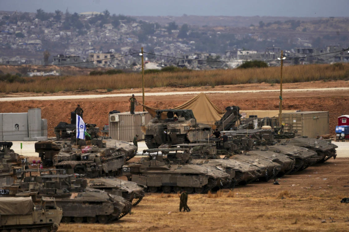 Israeli soldiers work on tanks and APCs at a staging area near the border with the Gaza Strip, in southern Israel, May 15, 2025. (AP)