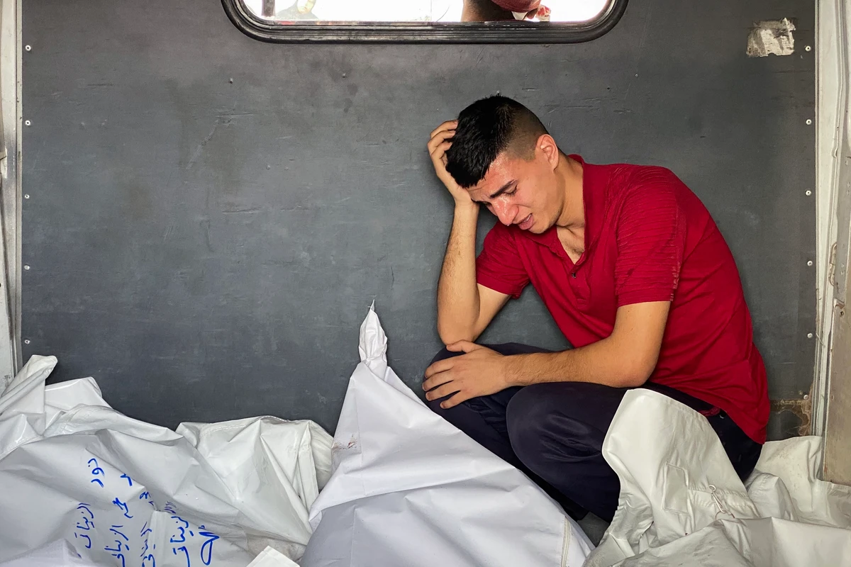 A Palestinian man mourns by bodies of casualties of Israeli strikes in the back of a vehicle ahead of burial, at the Nasser hospital in Khan Yunis in the southern Gaza Strip, May 15, 2025. (AFP)