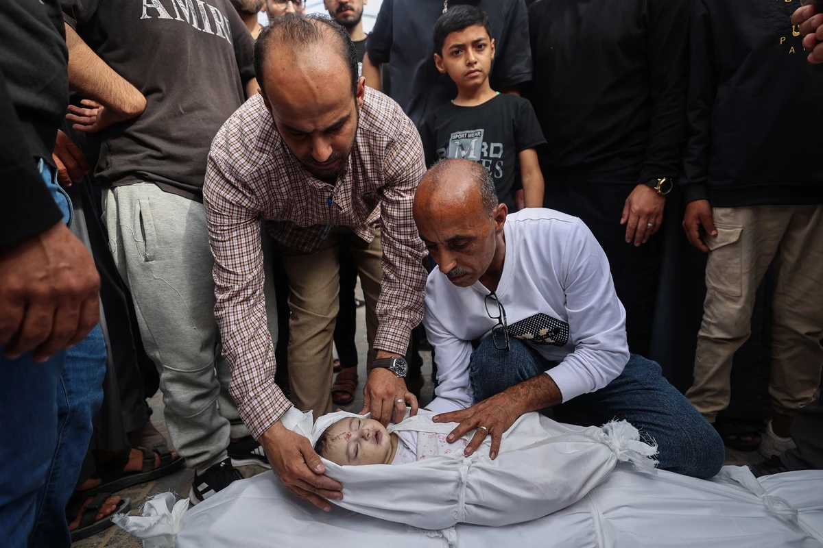 Relatives mourn by the bodies of four-month-old Aylul Abu Seif and her father Khaled who were killed in Israeli strikes, at the Al-Aqsa Martyrs hospital in central Gaza Strip, May 18, 2025. (AFP)