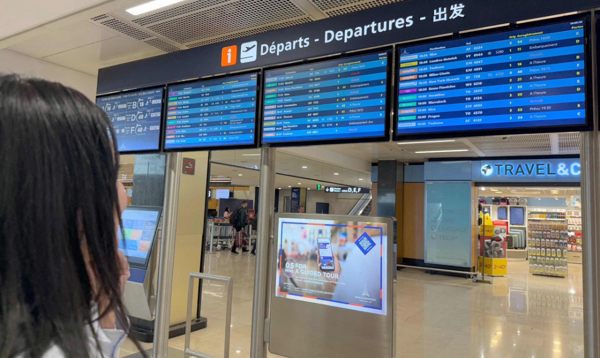 A traveller looks at flights informations boards during a breakdown in air traffic control systems at Paris-Orly airport in Orly, South of Paris, on May 18, 2025. (AFP)