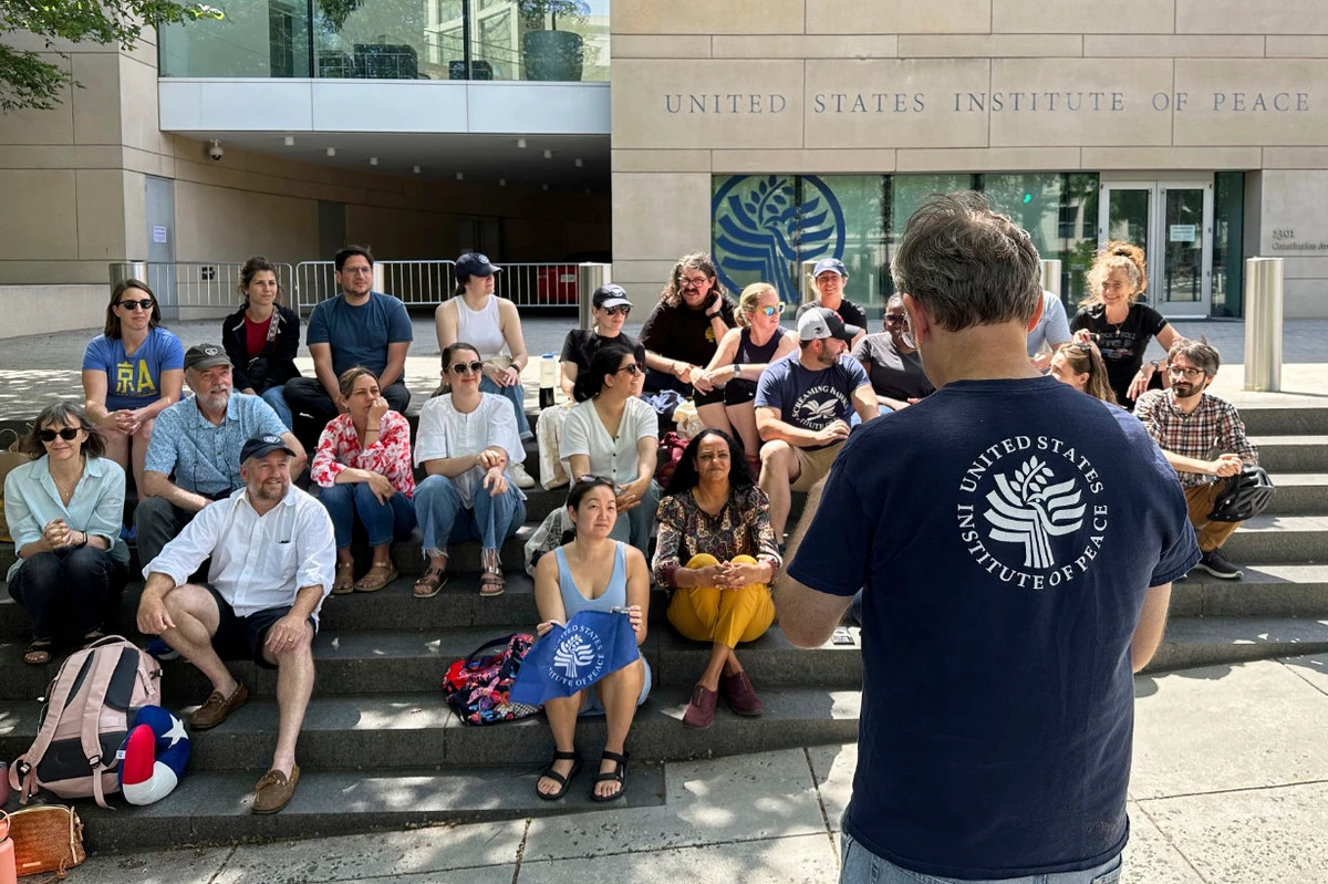 US Institute of Peace employees hold an impromptu celebration on the steps of the US Institute of Peace, Monday, May 19, 2025, in Washington, after federal district Judge Beryl A. Howell blocked the Trump administration from moving forward with the dismantling the organization. (AP)