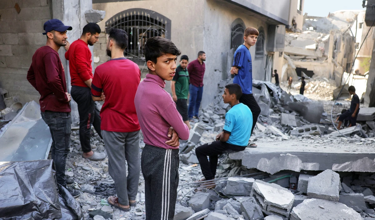 Palestinians check the devastation after Israeli bombing destroyed a home in Jabalia’s Saftawi neighborhood in the northern Gaza Strip on Thursday. (AFP)
