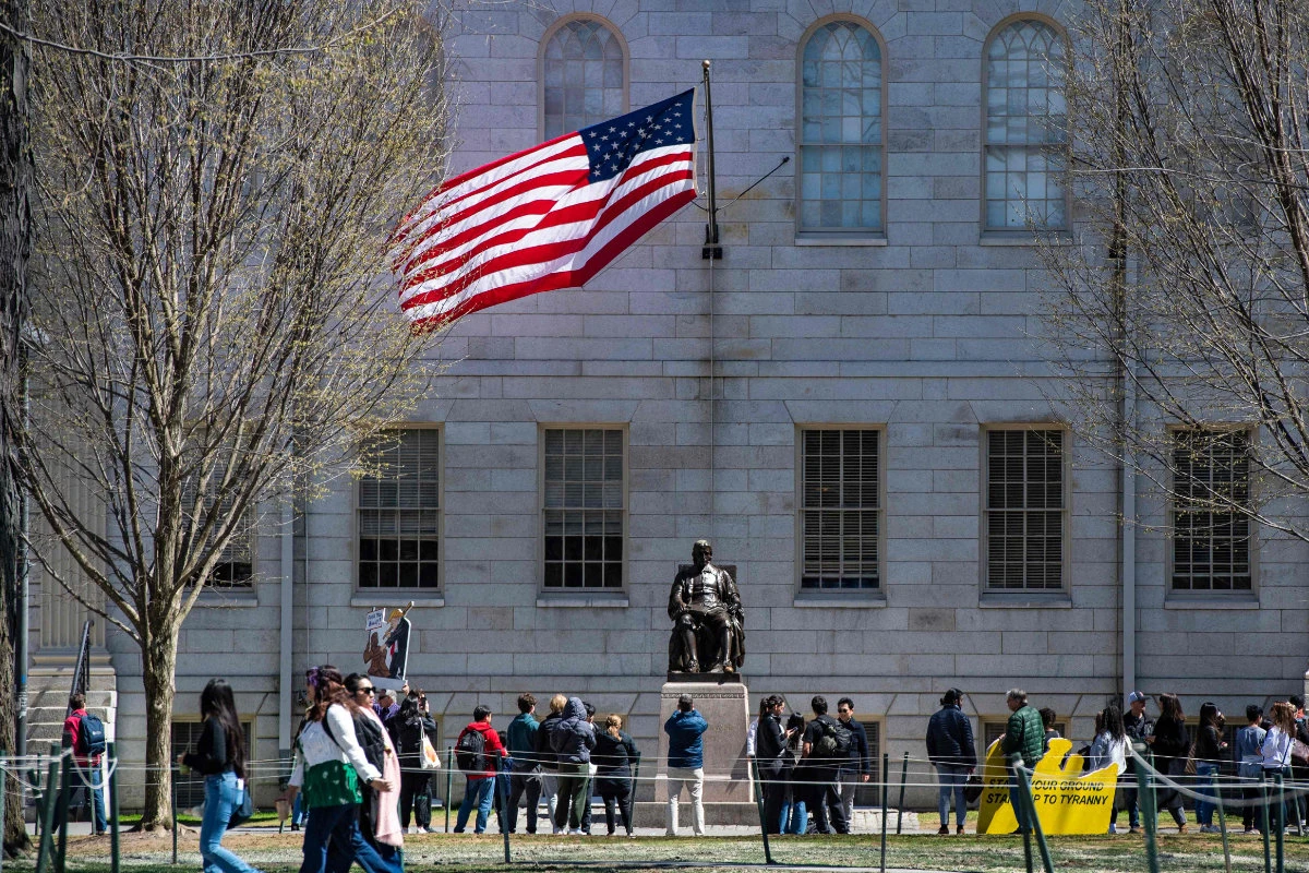 Demonstrators with signs stand around the John Harvard Statue in Harvard Yard in Cambridge, Massachusetts on April 17, 2025, during a rally against President Donald Trump’s attacks on Harvard University. (AFP)