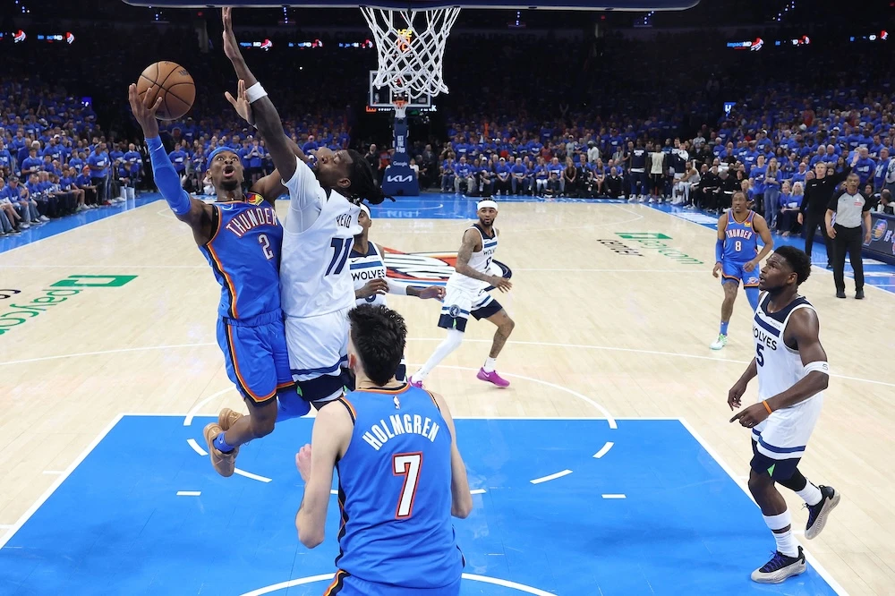 Shai Gilgeous-Alexander of the Oklahoma City Thunder shoots the ball as Naz Reid of the Minnesota Timberwolves defends in Game 2 of the Western Conference Finals of the 2025 NBA Playoffs on Thursday in Oklahoma City, Oklahoma. (Getty Images via AFP)