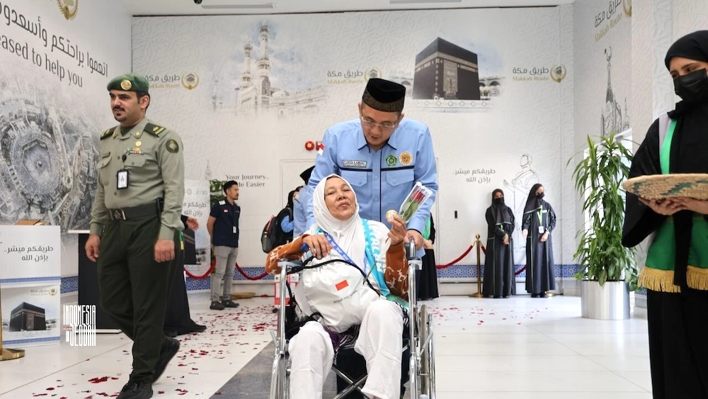 An Indonesian Hajj officer walks a pilgrim through the Makkah Route area at the King Abdulaziz airport in Jeddah on May 17, 2025. (KJRI Jeddah)