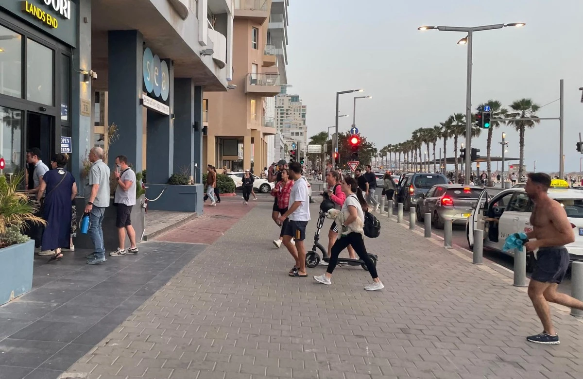 People run for cover during a missile alert in Tel Aviv on May 13, 2025. (AFP)