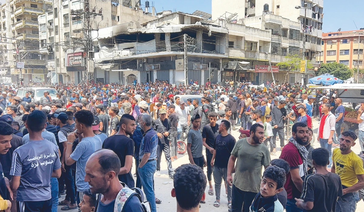 Palestinians wait to receive aid, in Gaza City, May 25, 2025. (REUTERS)