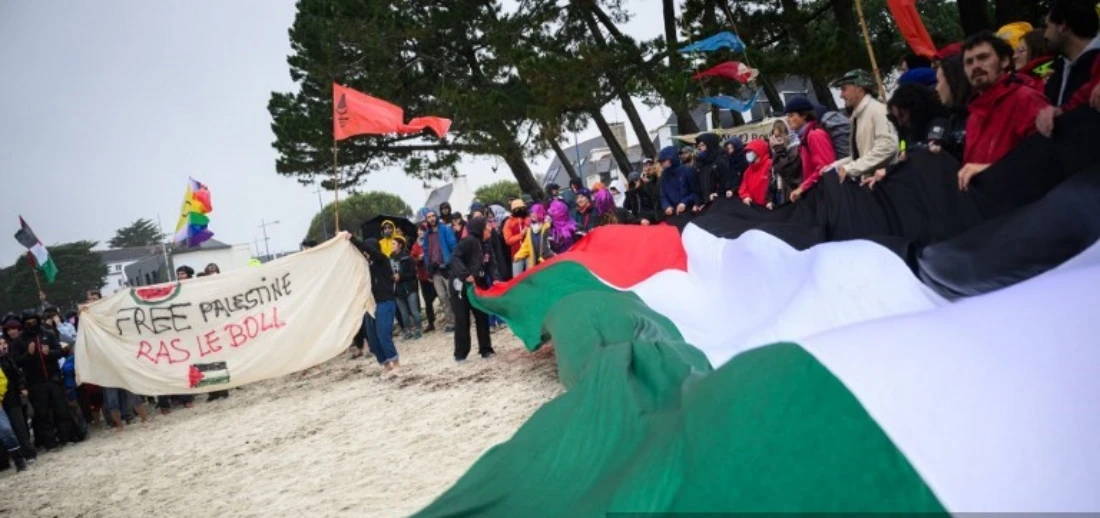 Protestors hold a Palestinian flag at a protest against the "Bollore empire" in Fouesnant, France. (AFP)