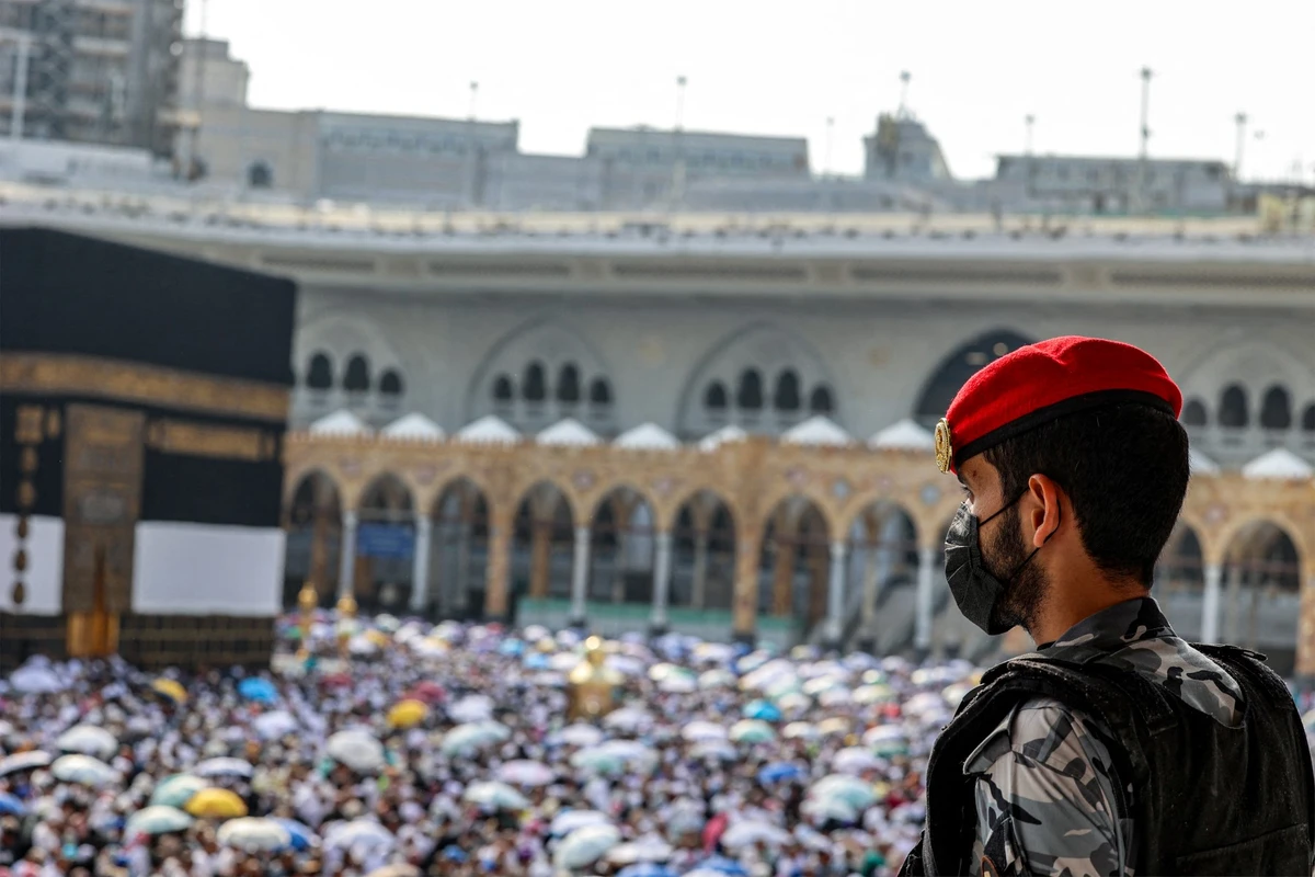 A Saudi security officer watches as Muslim pilgrims perform the farewell circumambulation or "tawaf", circling seven times around the Kaaba, Islam's holiest shrine, at the Grand Mosque in the holy city of Mecca on June 18, 2024 at the end of the annual hajj pilgrimage. (File/AFP)