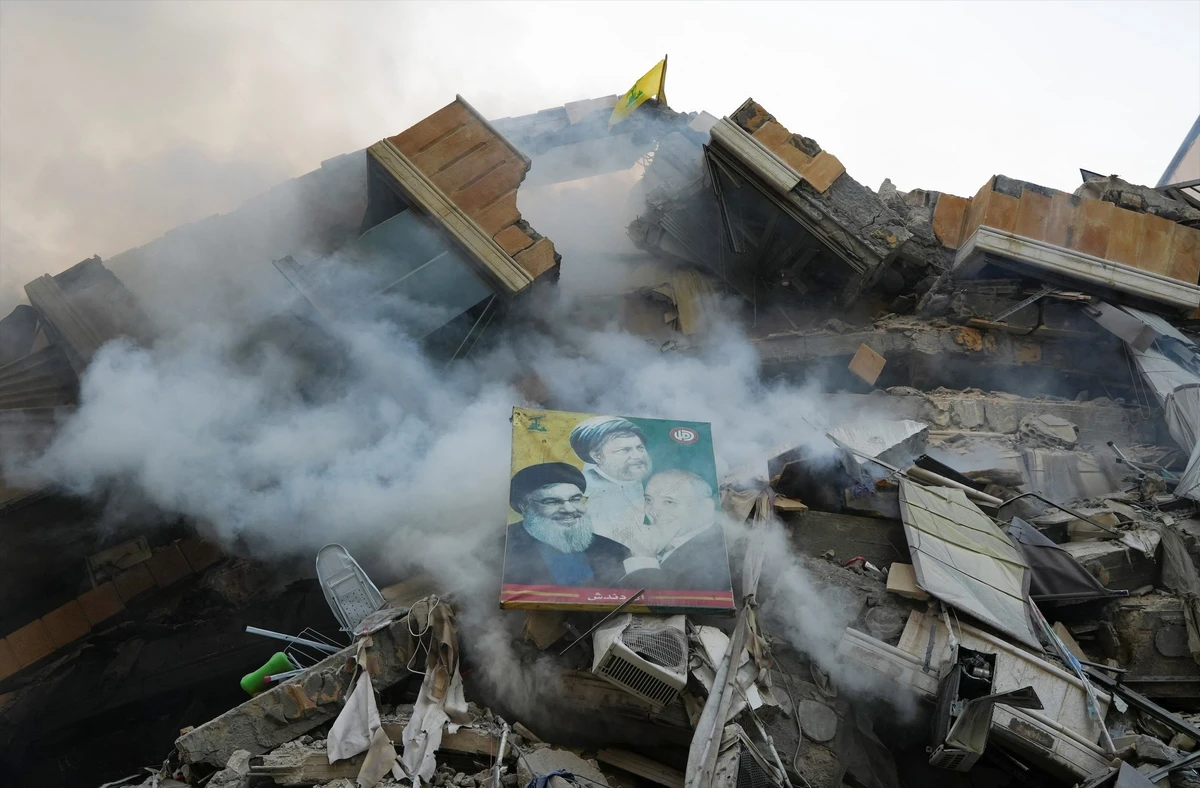 A poster depicting late Hezbollah leader Sayyed Hassan Nasrallah, Parliament Speaker Nabih Berri and the founder of the Shi'ite Amal movement Imam Musa al-Sadr, is placed on the rubble of damaged building. (Reuters)
