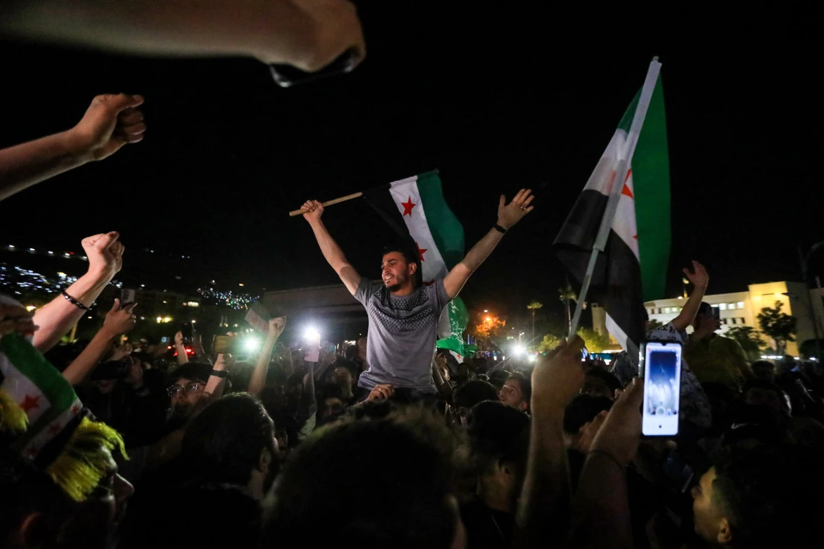 Syrians celebrate in Damascus' Omeyyad square on May 13, 2025, after US President Donald Trump's decision to lift sanctions in Syria. (AFP)