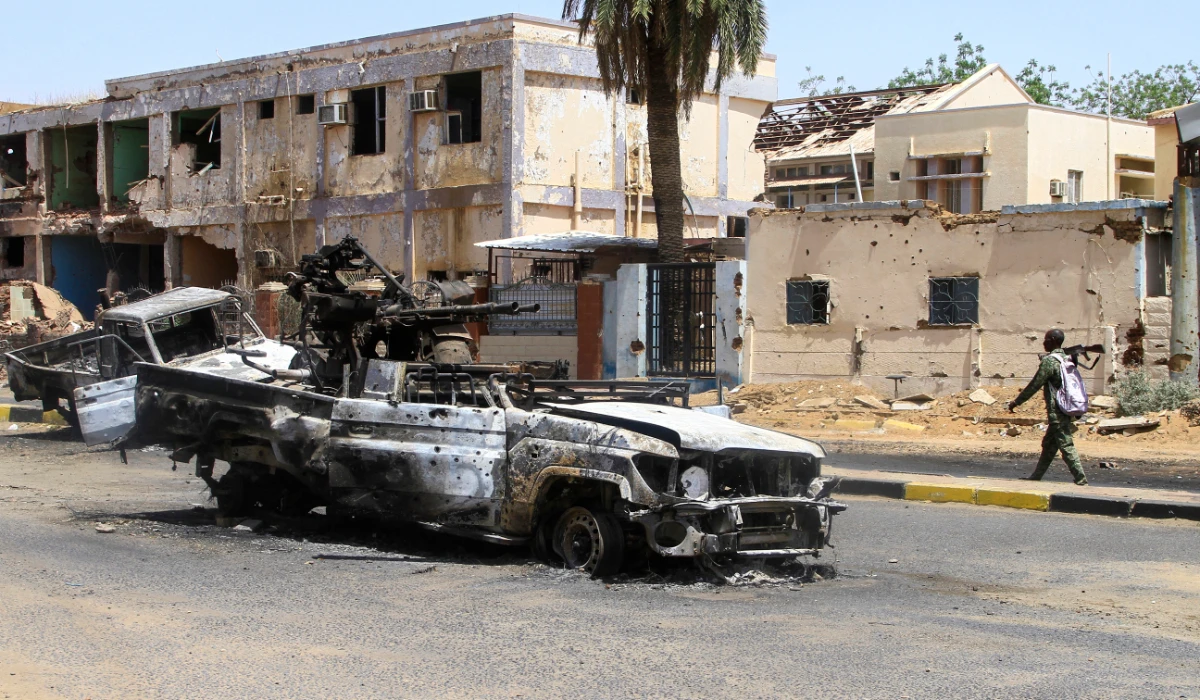 A Sudanese man walks past destroyed military vehicles in front of a hospital in Khartoum on April 28, 2025. (AFP)