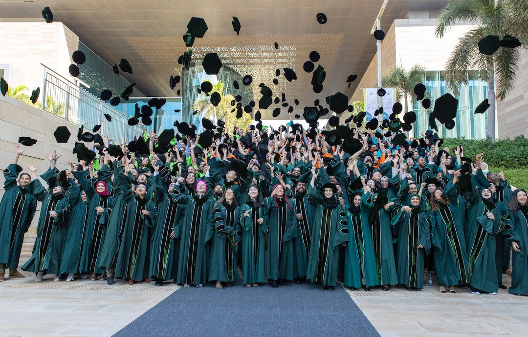 KAUST doctoral candidates throw their hats to the sky during a playful group photo during their graduation. (KAUST Photo)