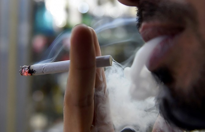 A man smokes outside a tobacco shop in the Saudi capital Riyadh late on June 11, 2017. (AFP/File)