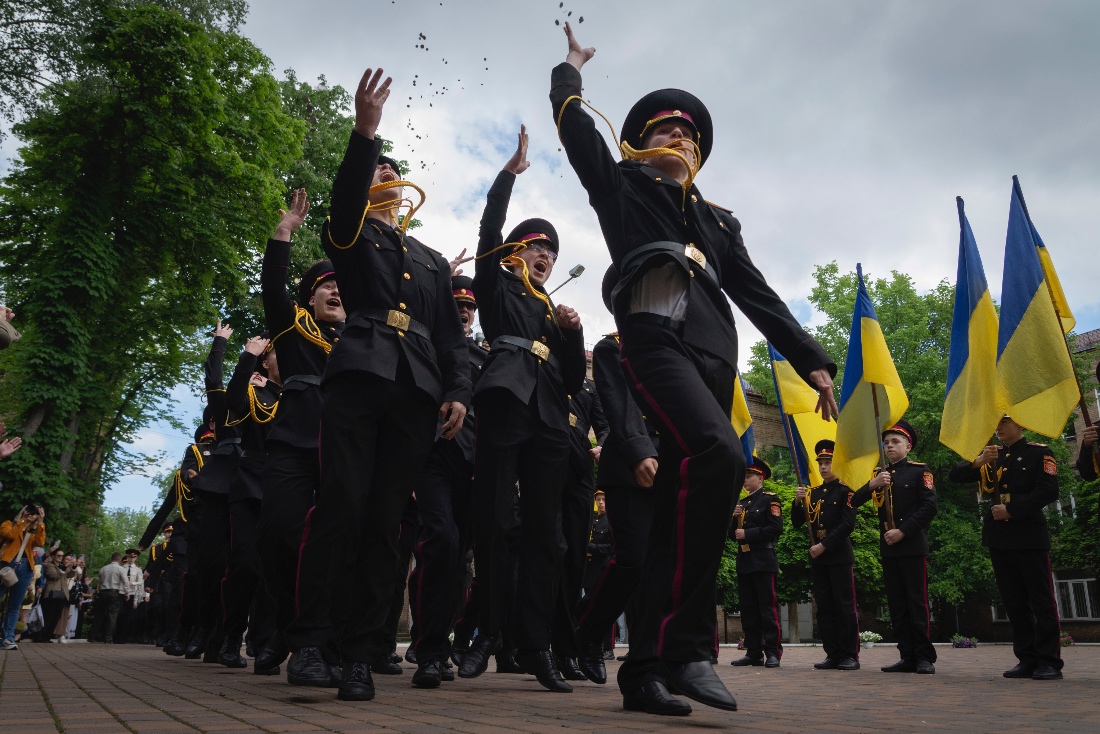 Graduate cadets toss coins in the air in celebration of their graduation in Kyiv, Ukraine. (AP)