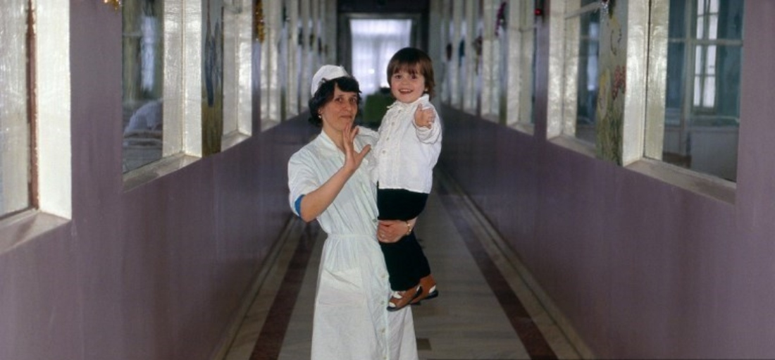 A child waves and smiles at an orphanage in Bucharest, Romania. (AFP)