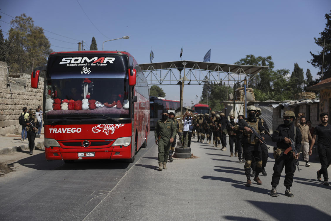 Syrian soldiers escort released prisoners during an exchange with the Kurdish-led Syrian Democratic Forces in the Sheikh Maqsoud neighborhood of Aleppo, Syria on Monday. (AP)
