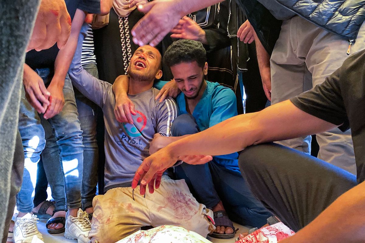 Palestinians mourn at Nasser hospital by the bodies of relatives who were killed by Israeli fire as they gathered near a US-backed aid center. (AFP)