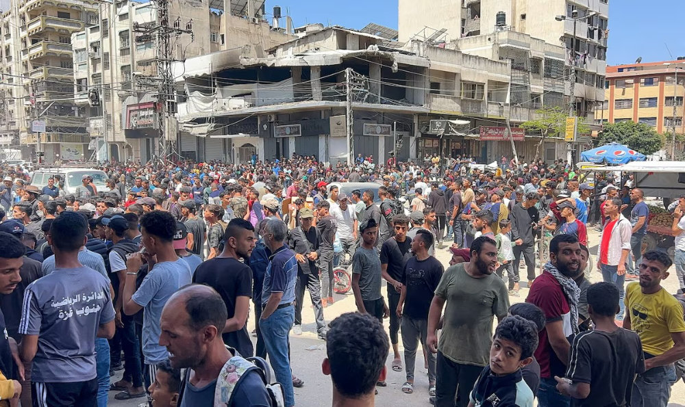 Palestinians wait to receive aid in Gaza City on May 25, 2025. (Reuters)