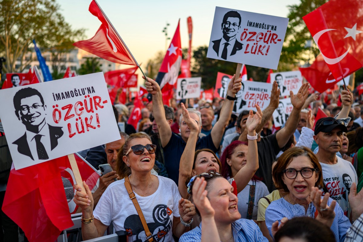 Protesters hold Turkish flags and placards reading 'Freedom for Imamoglu' as they take part in a demonstration against the detention of the Mayor of Istanbul, Ekrem Imamoglu. (File/AFP)